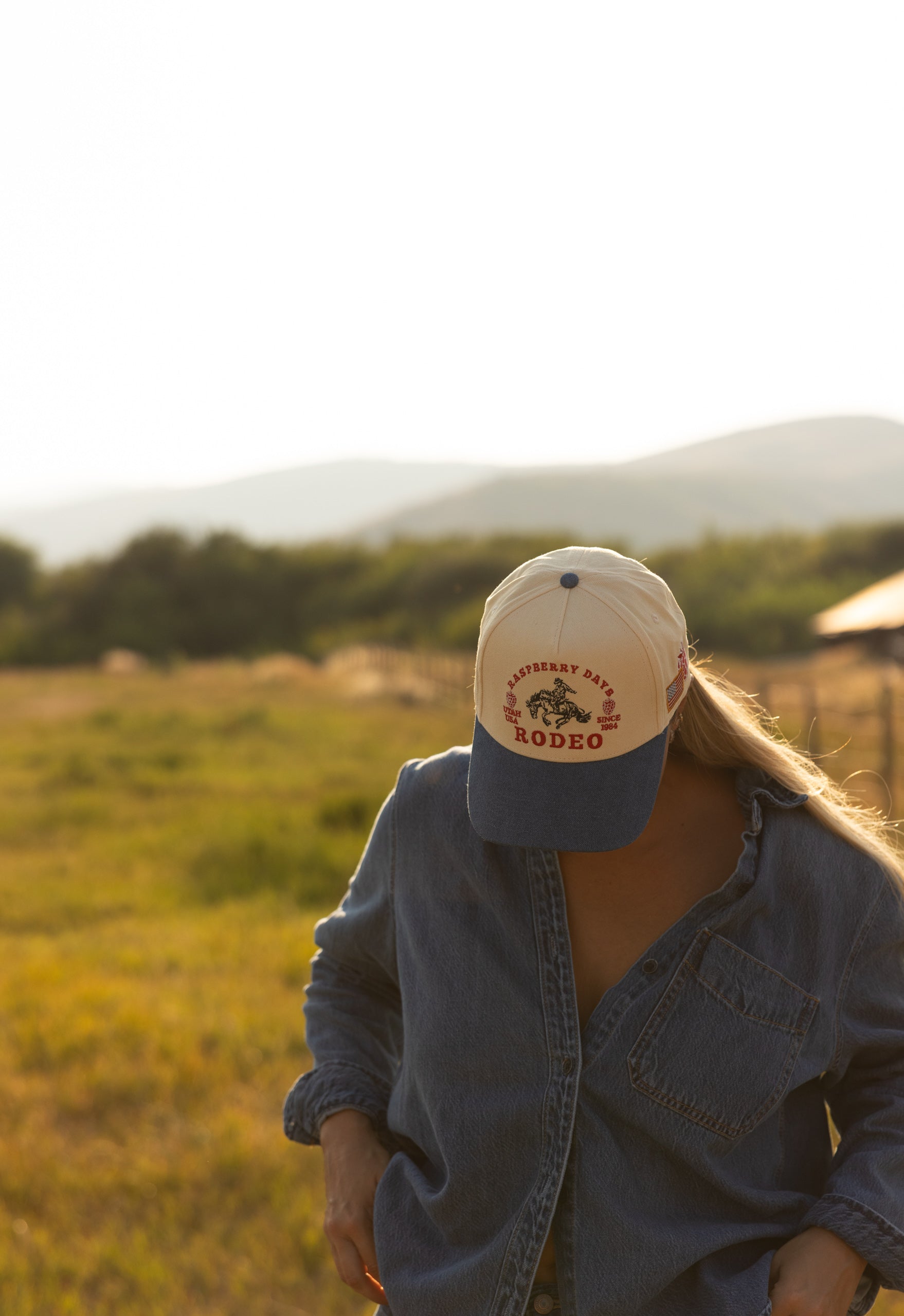 Woman in a Loud Face cap in a field at golden hour