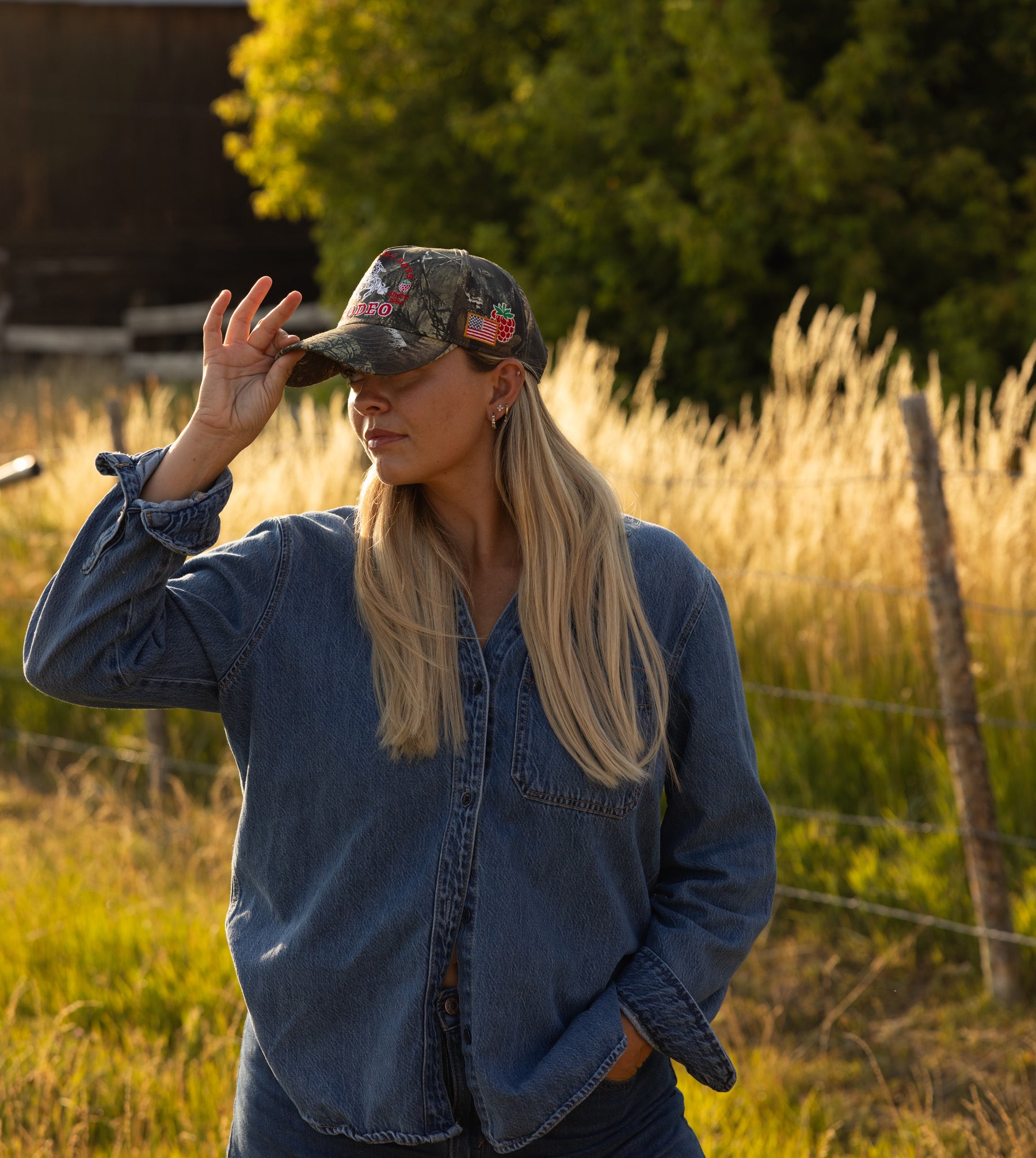 Woman in a camo Loud Face cap and denim jacket