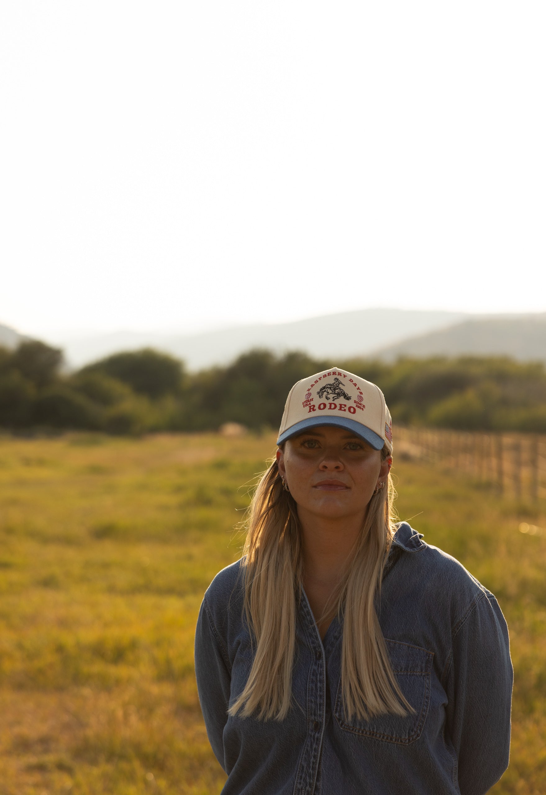 Woman in a Raspberry Days Rodeo cap in an open field