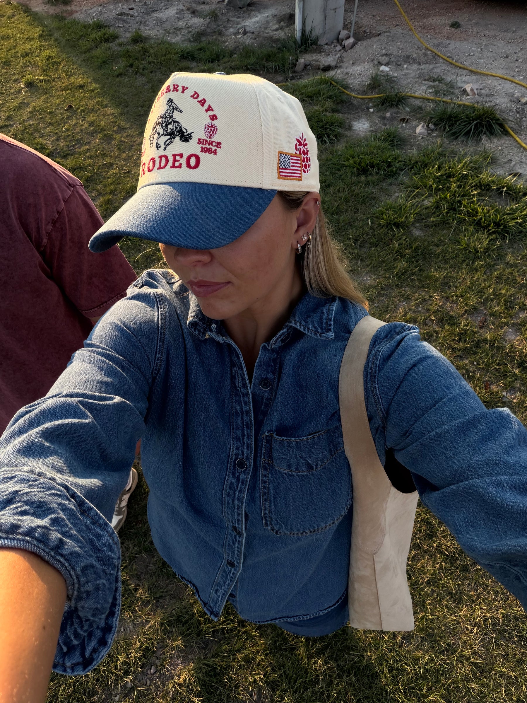 Woman in a denim jacket and Loud Face Raspberry Days cap