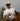 Man wearing an Alpine Days Rodeo cap and holding a lasso, standing next to a horse with a blurred background